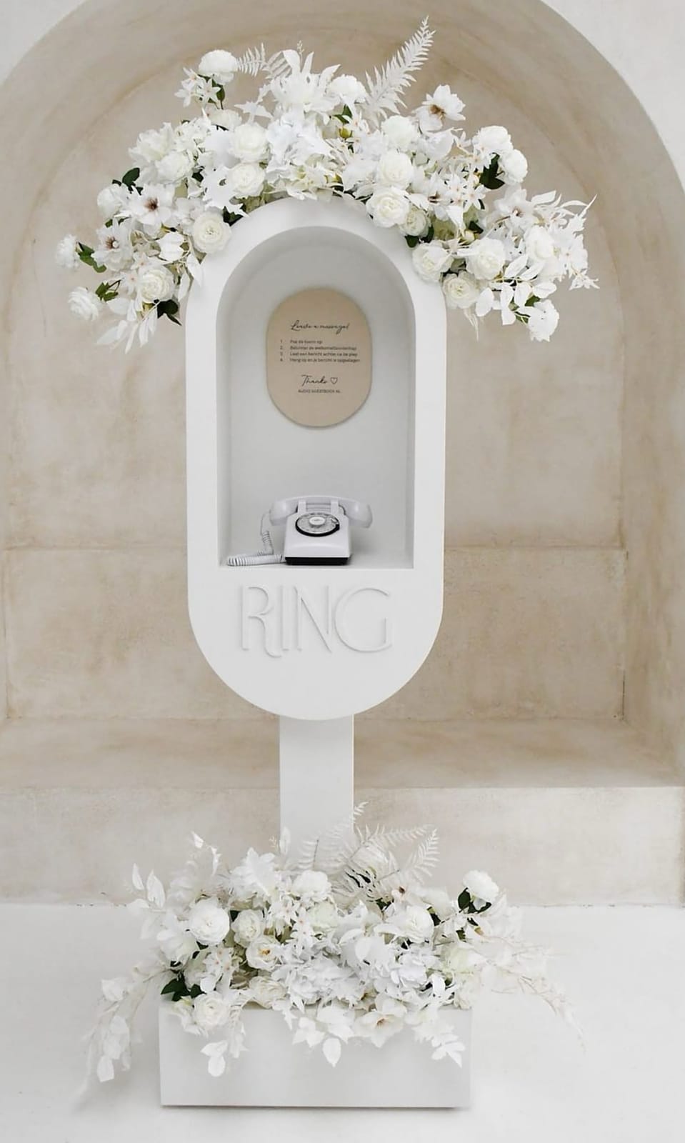 The white RING vintage phone booth styled with white florals at a Dallas wedding